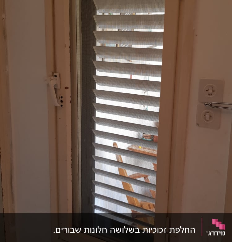 חלון עם זכוכית ותריסים סגורים